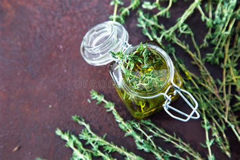 Immagine di un barattolo di vetro con timo e alcol in infusione