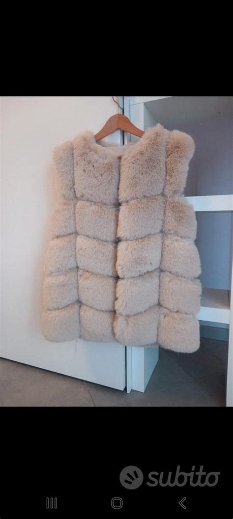 Una donna che indossa una pelliccia smanicata color champagne su un abito elegante