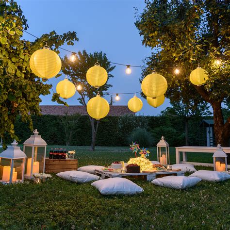 Giardino allestito per aperitivo con luci e cuscini colorati