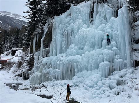 Cascata di ghiaccio imponente in un paesaggio montano innevato