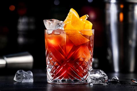 Immagine di un Negroni classico servito in un bicchiere old fashioned con una fetta d'arancia