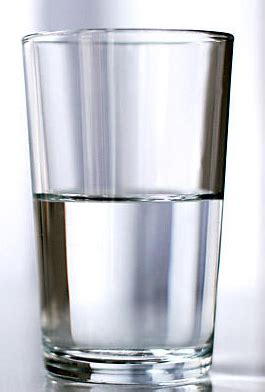 una persona che guarda un bicchiere mezzo vuoto e mezzo pieno