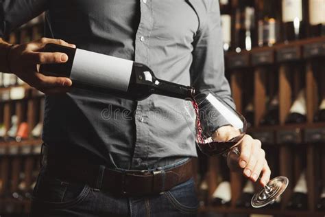 Un sommelier che versa vino in un bicchiere