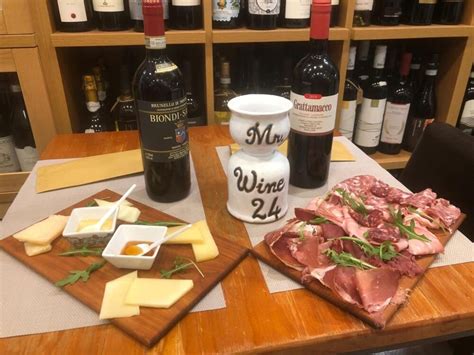 Interno di un'enoteca tradizionale con bottiglie di vino e taglieri di salumi