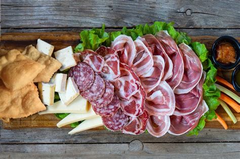 Un assortimento di salumi e formaggi su un tagliere rustico