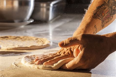 Stesura manuale dell'impasto per pizza