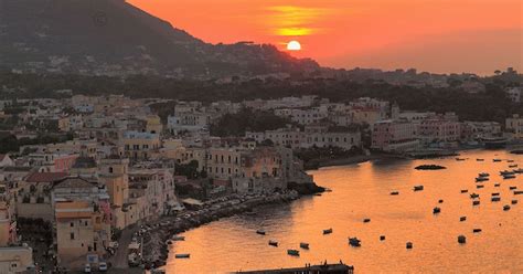 Vista panoramica del porto di Ischia al tramonto con bar in primo piano