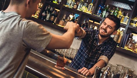 Un bartender che esegue una complessa manovra di versaggio con due bottiglie