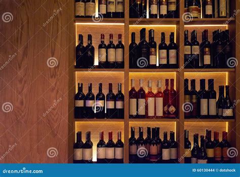 bottiglie di vino e liquori disposte su uno scaffale in una cantina