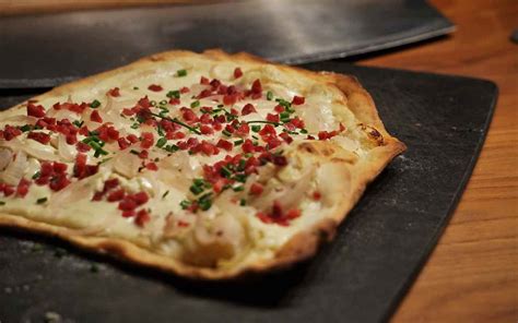 Un piatto di Tarte Flambée con ingredienti freschi