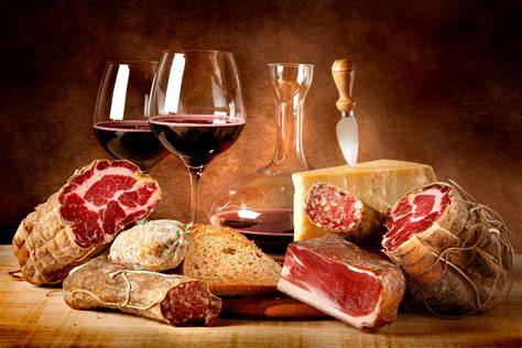 Selezione di formaggi e salumi locali con un bicchiere di vino