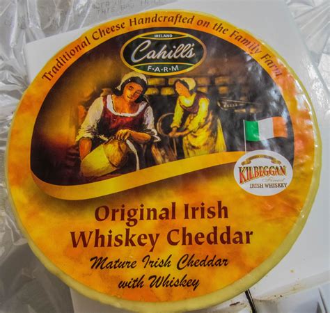 Formaggio Cahill's Irish Whiskey Cheddar tagliato a fette con un bicchiere di whisky irlandese