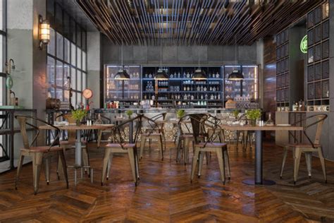 Interno di un brew pub con tavoli, bancone e fermentatori