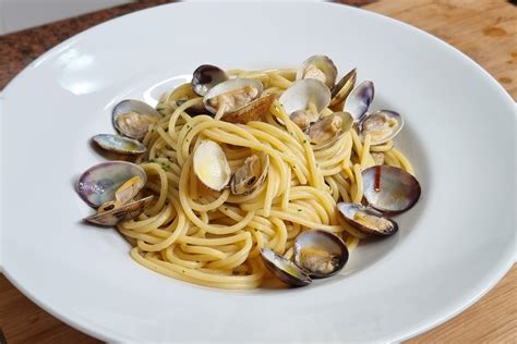 Piatto di spaghetti alle vongole con un bicchiere di Fiano di Avellino
