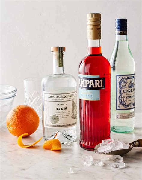 Ingredients for a Negroni cocktail: gin, Campari, sweet vermouth, orange slice