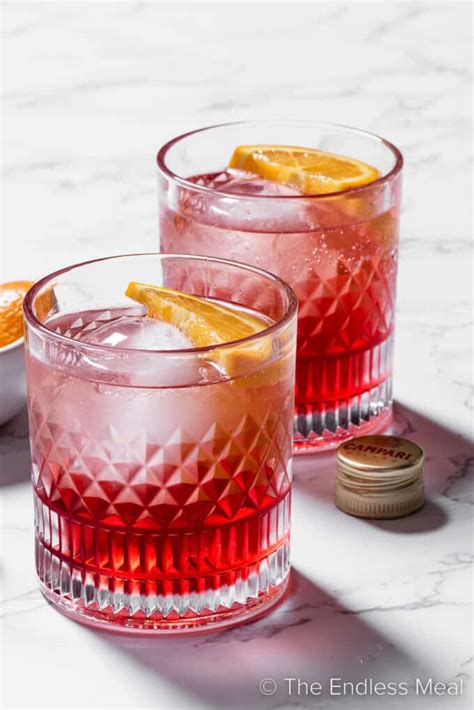 A Negroni Sbagliato cocktail with a slice of orange