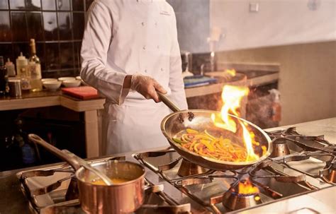 mani che eseguono la tecnica del flambé su un cocktail