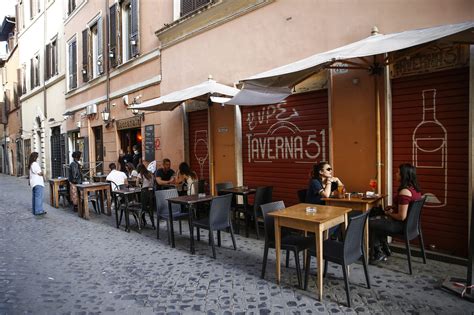 Vista panoramica di una piazza italiana con tavolini all'aperto per aperitivo