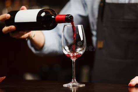 Sommelier che versa vino in un bicchiere