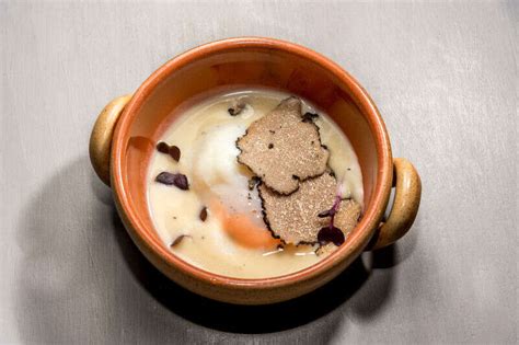 Piatto di fonduta al tartufo con crostini e bicchiere di vino bianco