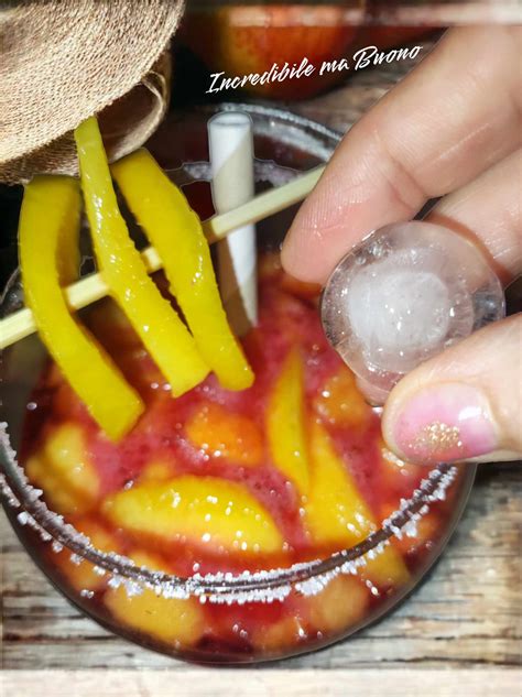 bicchiere con cocktail alla pesca e ghiaccio